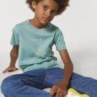 Tshirt enfant manche courte en coton biologique. De couleur turquoise avec le dessin d'une baleine et des motifs polynésiens. La couleur de la sérigraphie est beige.