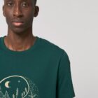 Tshirt homme manche courte coton biologique couleur vert sapin avec le dessin d'un yin et yang de la nature, d'un coté les montagnes et de l'autre la plage la sérigraphie est de couleur beige.