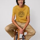 Tshirt homme manche courte coton biologique couleur ocre avec le dessin d'un bouddha sur des racines et entouré de branches d'arbre, la sérigraphie est de couleur noir.