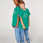 Tshirt enfant manche courte en coton biologique de couleur vert émeraude avec le dessin d'un bouddha sur des racines et entouré de branches d'arbre, la sérigraphie est de couleur beige.