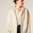 Veste sweat femme en coton biologique de la couleur naturel du coton avec le logo de la marque sur la manche en sérigraphie doré.