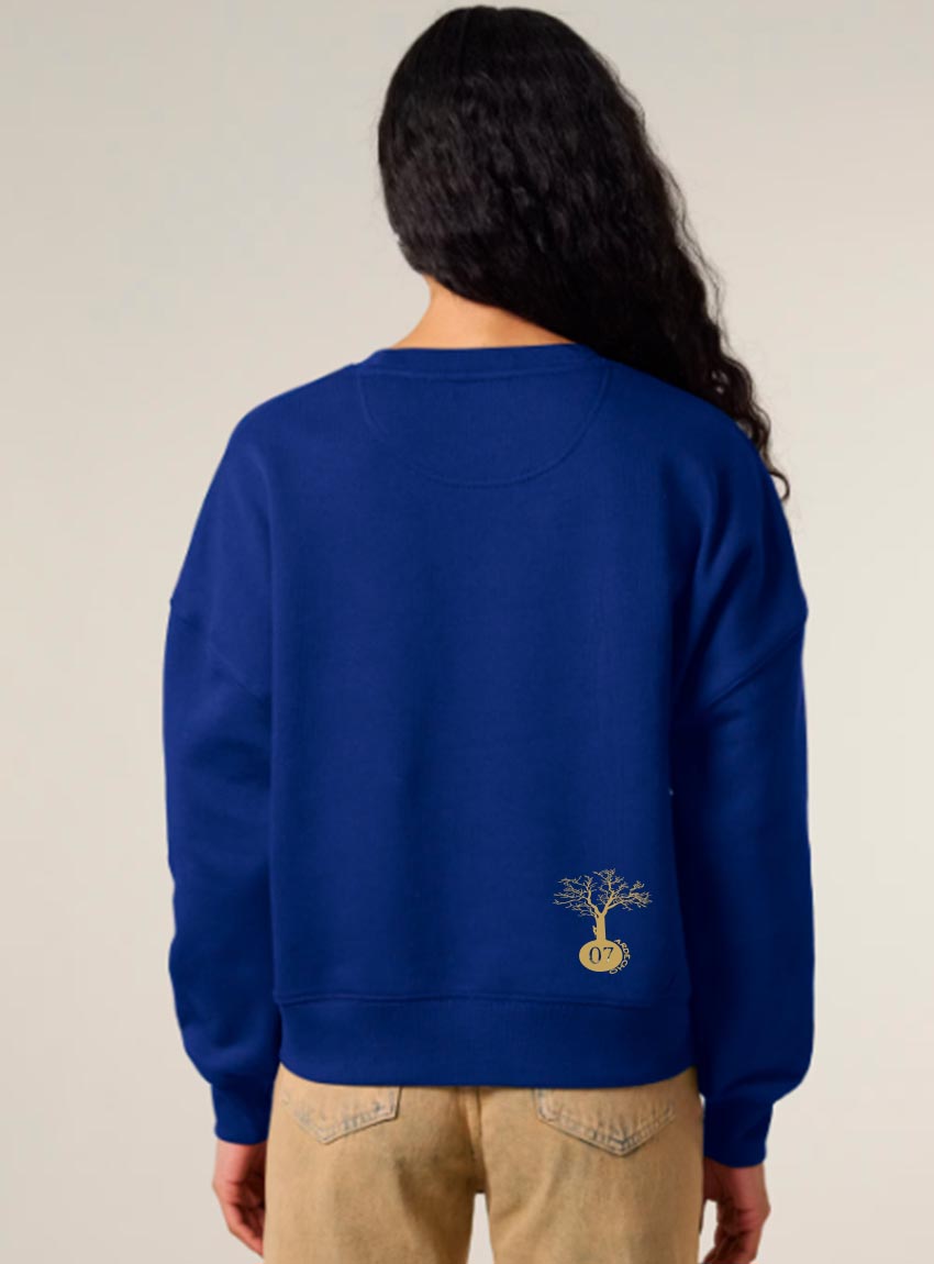 Sweat femme en coton biologique de couleur bleu indigo avec une sérigraphie doré en bas dans le dos représentant un arbre sur une planète.