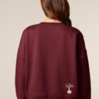 Sweat femme en coton biologique de couleur bordeau avec une sérigraphie beige en bas dans le dos représentant un arbre sur une planète.