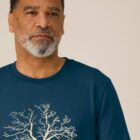 Tshirt homme manche courte couleur bleu denim avec le dessin d'un arbre sur une planète et sérigraphie de couleur beige.