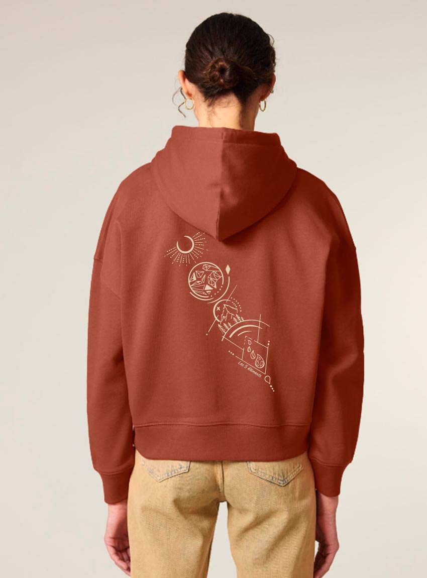Sweat bio femme avec capuche de couleur terracotta avec un dessin dans le dos représentant les cinq éléments de la nature. La couleur de sérigraphie est beige.