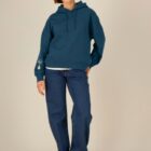Sweat bio femme avec capuche de couleur bleu denim avec le dessin de la marque sur la manche représentant un homme qui grimpe sur un arbre au dessus de la planète. La couleur de sérigraphie est beige.
