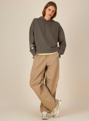 Sweat bio femme avec capuche de couleur mocha avec le dessin de la marque sur la manche représentant un homme qui grimpe sur un arbre au dessus de la planète. La couleur de sérigraphie est beige.