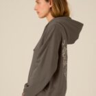 Sweat bio femme avec capuche de couleur mocha avec un dessin dans le dos représentant les cinq éléments de la nature. La couleur de sérigraphie est beige.