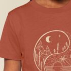 Tshirt enfant manche courte coton biologique couleur terracotta avec le dessin d'un yin et yang de la nature, d'un coté les montagnes et de l'autre la plage la sérigraphie est de couleur beige.