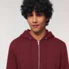 Veste sweat pour homme et femme en coton biologique de couleur bordeau avec un dessin sur la manche d'un arbre et d'une planète, la sérigraphie est de couleur beige.