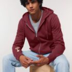 Veste sweat pour homme et femme en coton biologique de couleur bordeau avec un dessin sur la manche d'un arbre et d'une planète, la sérigraphie est de couleur beige.