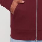 Veste sweat pour homme et femme en coton biologique de couleur bordeau avec un dessin sur la manche d'un arbre et d'une planète, la sérigraphie est de couleur beige.