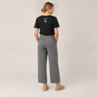 T-shirt femme manche courte en coton biologique de couleur noir vue de dos avec le dessin de la marque entre les épaules et la sérigraphie est de couleur argenté.