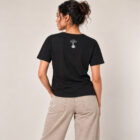 T-shirt femme manche courte en coton biologique de couleur noir vue de dos avec le dessin de la marque entre les épaules et la sérigraphie est de couleur argenté.