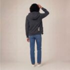 Photo de présentation du sweat à capuche unisexe Polaire, en coton biologique, coloris anthracite, porté par un modèle femme. Collection Ardecho 07. Vue de dos avec le dessin de la marque en bas à droite, représentant un arbre sur la planète et un homme qui grimpe à l'arbre, la sérigraphie est de couleur beige.