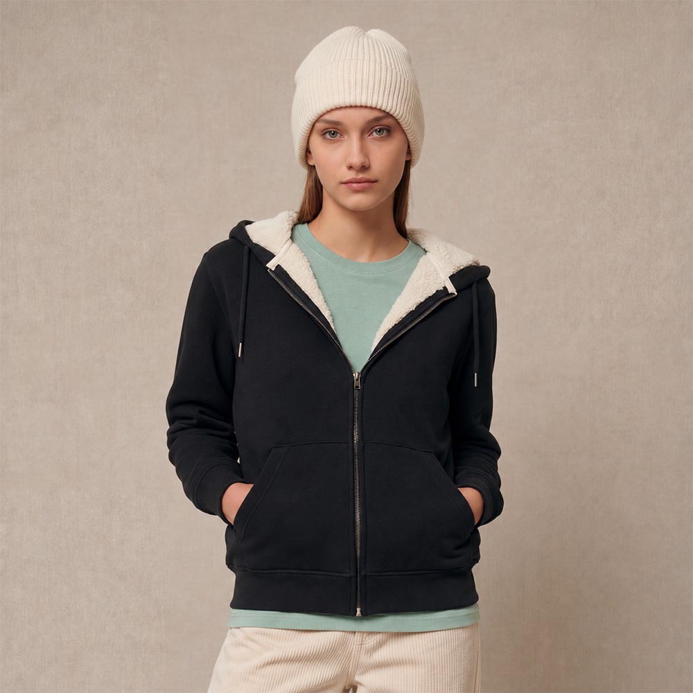 Photo de présentation du sweat à capuche zippé unisexe Polaire, en coton biologique, coloris noir, porté par un modèle femme. Collection Ardecho 07. Zoom sur la polaire.