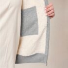 Photo de présentation du sweat à capuche zippé unisexe Polaire, en coton biologique, coloris gris chiné, porté par un modèle femme. Collection Ardecho 07. Zoom sur l'intérieur fourré de la polaire.
