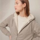 Photo de présentation du sweat à capuche zippé unisexe Polaire, en coton biologique, coloris crème chiné, porté par un modèle femme. Collection Ardecho 07. Zoom sur la polaire.