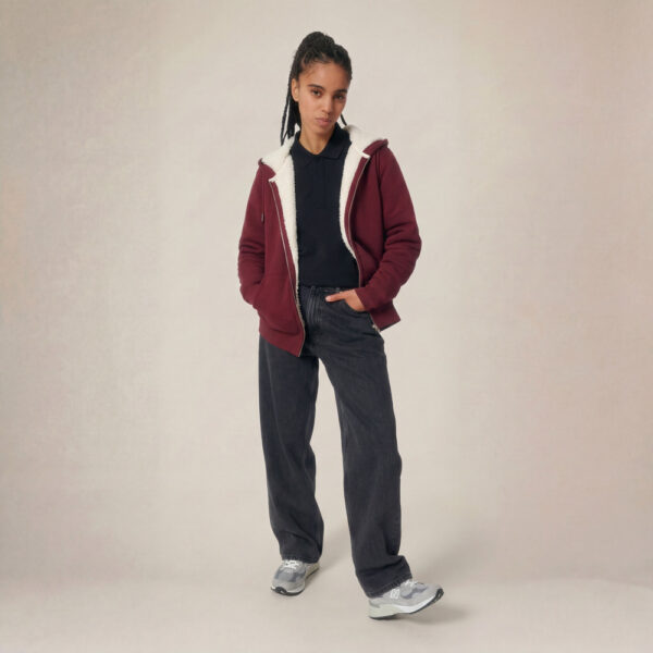 Photo de présentation du sweat à capuche zippé unisexe Polaire, en coton biologique, coloris bordeaux, porté par un modèle femme. Collection Ardecho 07.