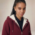 Photo de présentation du sweat à capuche zippé unisexe Polaire, en coton biologique, coloris bordeaux, porté par un modèle femme. Collection Ardecho 07. Zoom sur la polaire.