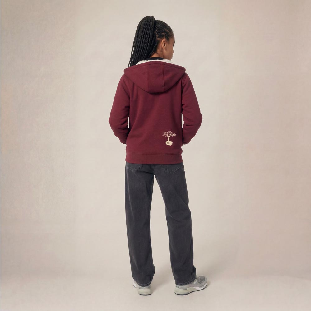 Photo de présentation du sweat à capuche unisexe Polaire, en coton biologique, coloris bordeaux, porté par un modèle femme. Collection Ardecho 07. Vue de dos avec le dessin de la marque en bas à droite, représentant un arbre sur la planète et un homme qui grimpe à l'arbre, la sérigraphie est de couleur beige.