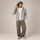 Photo de présentation du sweat à capuche zippé unisexe Polaire, en coton biologique, coloris gris chiné, porté par un modèle homme. Collection Ardecho 07.