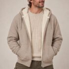 Photo de présentation du sweat à capuche zippé unisexe Polaire, en coton biologique, coloris crème chiné, porté par un modèle homme. Collection Ardecho 07. Zoom sur la polaire.