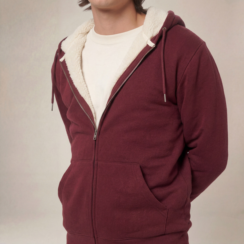 Photo de présentation du sweat à capuche zippé unisexe Polaire, en coton biologique, coloris bordeaux, porté par un modèle homme. Collection Ardecho 07. Zoom sur la polaire.