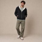 Photo de présentation du sweat à capuche zippé unisexe Polaire, en coton biologique, coloris noir, porté par un modèle homme. Collection Ardecho 07.