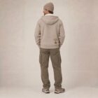 Photo de présentation du sweat à capuche zippé unisexe Polaire, en coton biologique, coloris crème chiné, porté par un modèle homme. Collection Ardecho 07. Zoom sur la polaire de dos avec le dessin de la marque en bas à droite, représentant un arbre sur la planète et un homme qui grimpe à l'arbre, la sérigraphie est de couleur marron.