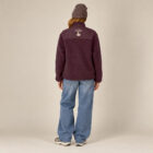 Polaire polyester recyclé femme couleur aubergine avec le dessin de la marque entre les épaules représentant un arbre sur la planète et un homme qui grimpe à l'arbre, sérigraphie de couleur beige. Vue de dos.