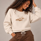 Sweat femme en coton biologique de couleur écru avec le dessin d'une montagne et écrit silence, la sérigraphie est de couleur marron. Zoom sur le sweat.