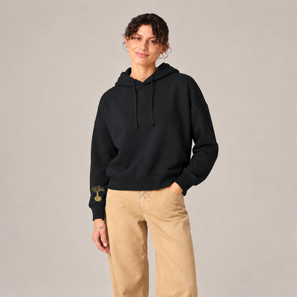 Sweat femme coton bio noir Cinq Eléments – Ardecho07 Sweat avec capuche femme en coton biologique de couleur noir avec le dessin de la marque sur la manche représentant un arbre sur une planète et une personne qui monte dans l'arbre. Sérigraphie doré, Vue de face.