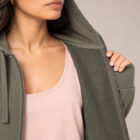Sweat coton bio femme avec une capuche couleur kaki et une fermeture éclaire. Vue de face avec zoom sur la veste. ouverte.