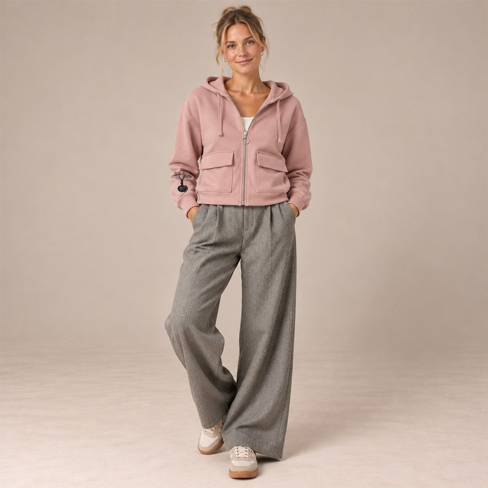 Sweat femme coton bio rosé Yin Yang – Ardecho07 Sweat coton bio femme avec une capuche couleur rosé et une fermeture éclaire. Vue de face. Dessin de la marque sur la manche de couleur noir, représentant un arbre sur la planète et une personne qui grimpe à l'arbre.