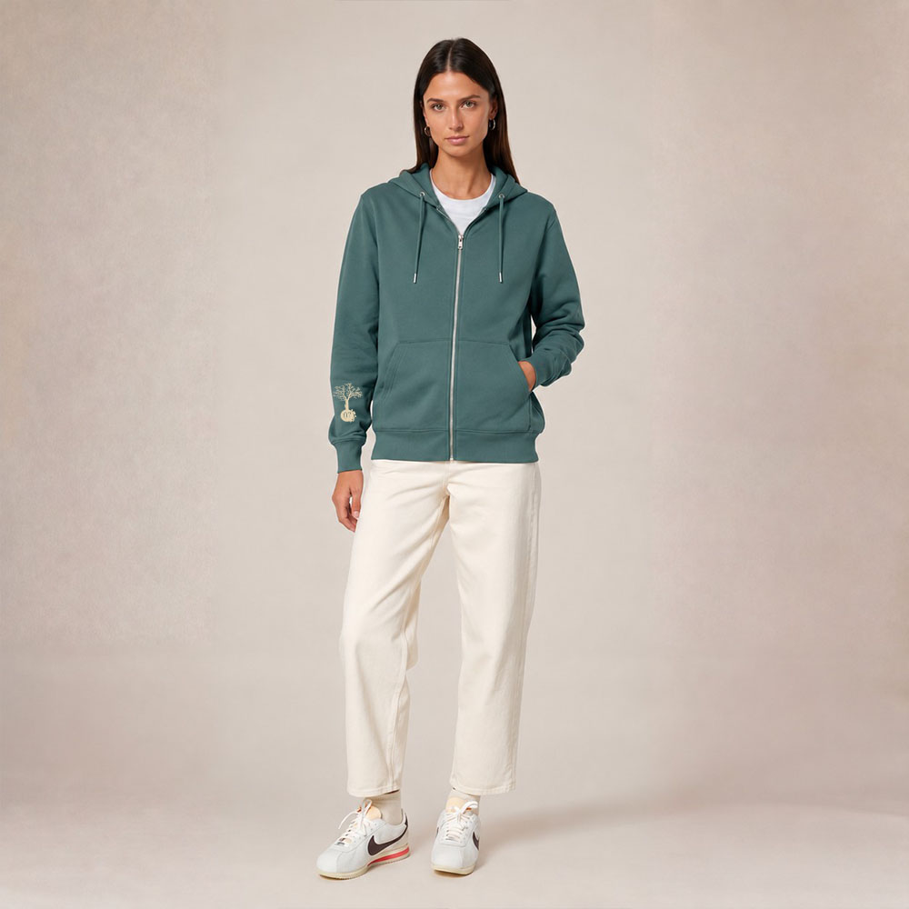 Sweat avec capuche et fermeture éclaire pour femme en coton biologique de couleur vert jade. Le logo de la marque est imprimé en beige sur la manche, un arbre sur une planète et un homme qui monte à l'arbre.
