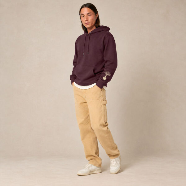 Sweat homme à capuche en coton biologique couleur aubergine avec le dessin du logo de la marque qui représente un arbre sur une planète et une personne qui monte à l'arbre. Poche kangourou, le dessin est sur la manche de couleur beige.