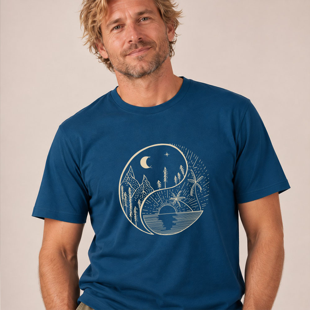 T-shirt homme manche courte en coton biologique couleur bleu denim avec le dessin d'un yin et yang de la nature, d'un coté les montagnes et de l'autre la plage la sérigraphie est de couleur beige. Zoom sur le t-shirt.