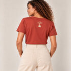 T-shirt femme manche courte en coton biologique de couleur terracotta vue de dos avec le dessin de la marque entre les épaules et la sérigraphie est de couleur beige.
