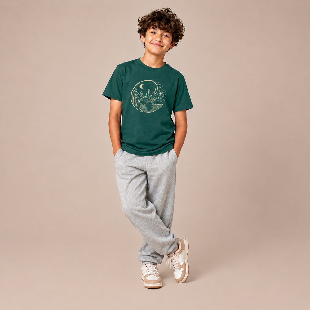 T-shirt enfant manche courte en coton biologique couleur vert sapin avec le dessin d'un yin et yang de la nature, d'un coté les montagnes et de l'autre la plage la sérigraphie est de couleur beige.