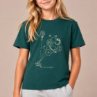 T-shirt enfant manche courte en coton biologique de couleur vert sapin avec un dessin représentant des planètes en forme de ballons tenu par le petit prince et son renard. La couleur de sérigraphie est beige. Zoom sur le t-shirt.