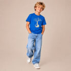 T-shirt enfant manche courte en coton biologique couleur bleu roi avec le dessin d'un arbre sur une planète et sérigraphie de couleur beige.