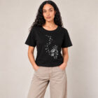 T-shirt femme à manche courte en coton biologique couleur noir avec un dessin d'abeilles s'envolant d'un pissenlit . Avec une inscription ' Bee la vie ', la sérigraphie est de couleur argenté. Zoom sur le t-shirt.