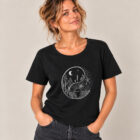 T-shirt femme manche courte en coton biologique couleur noir avec le dessin d'un yin et yang de la nature, d'un coté les montagnes et de l'autre la plage la sérigraphie est de couleur argenté. Zoom sur le t-shirt.