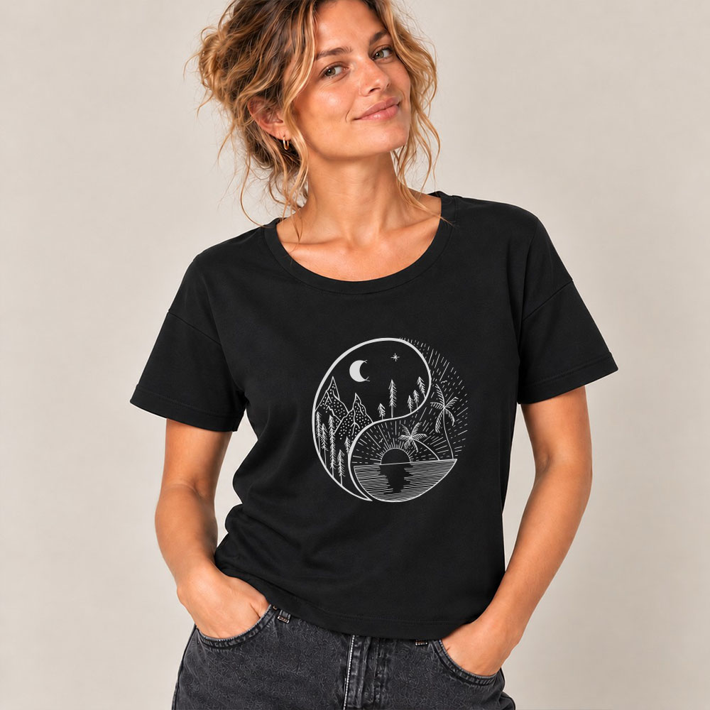 T-shirt femme manche courte en coton biologique couleur noir avec le dessin d'un yin et yang de la nature, d'un coté les montagnes et de l'autre la plage la sérigraphie est de couleur argenté. Zoom sur le t-shirt.