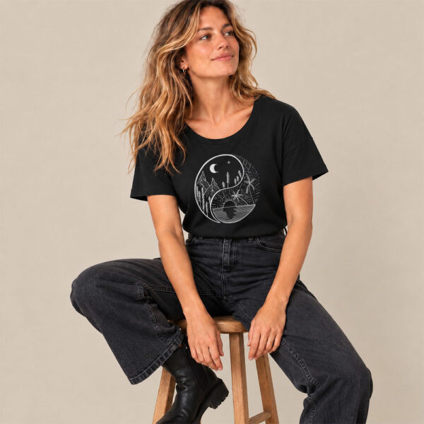 T-shirt femme manche courte en coton biologique couleur noir avec le dessin d'un yin et yang de la nature, d'un coté les montagnes et de l'autre la plage la sérigraphie est de couleur argenté.