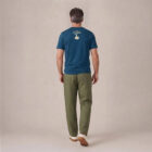 T-shirt homme manche courte en coton biologique de couleur bleu denim vue de dos avec le dessin de la marque entre les épaules et la sérigraphie est de couleur beige.