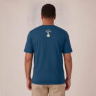 T-shirt homme manche courte en coton biologique de couleur bleu denim vue de dos avec le dessin de la marque entre les épaules et la sérigraphie est de couleur beige.