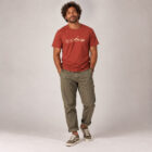 T-shirt homme manche courte en coton biologique de couleur rouge lave avec un dessin représentant les éléments de la nature sur une ligne avec l'inscription des racines aux étoiles la de sérigraphie est de couleur beige.