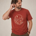 T-shirt homme manche courte en coton biologique couleur rouge lave avec le dessin d'un yin et yang de la nature, d'un coté les montagnes et de l'autre la plage la sérigraphie est de couleur beige. Zoom sur le t-shirt.